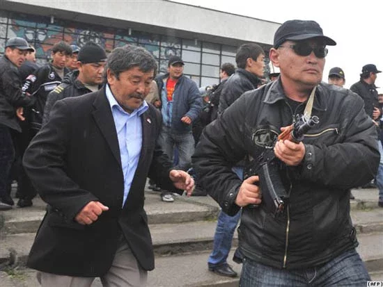  Курманбек Бакіеў з ахоўнікамі сыходзіць з няўдалага мітынгу ў горадзе Ош. Фота AFP.