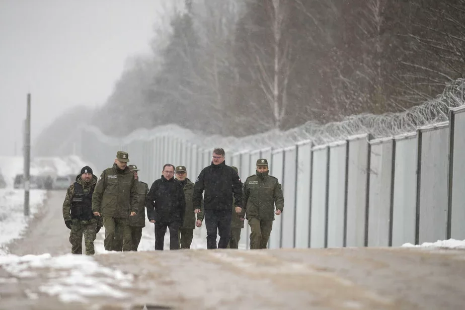 Польские чиновники и пограничники у пограничной стены. Фото AP Photo / Maciek Luczniewski