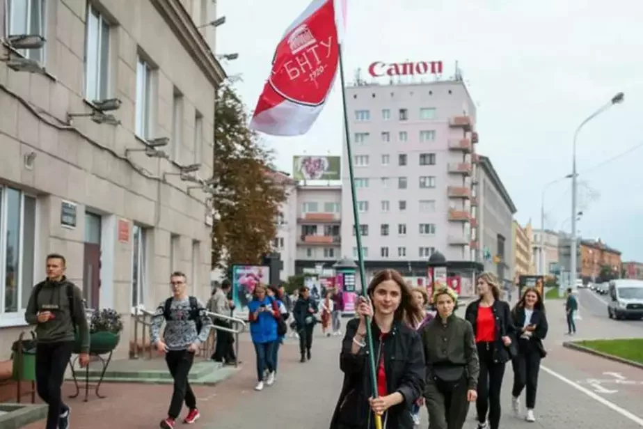 Анастасия Булыбенко с флагом БНТУ на проспекте Независимости возле своего университета.