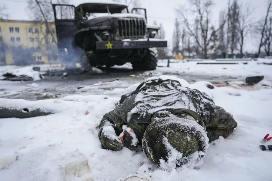 Цела вайскоўца засыпана снегам побач са знішчанай расейскай вайсковай рэактыўнай сістэмай залпавага агню на ўскраіне Харкава, Украіна, 25 лютага 2022 г. Фота: AP 