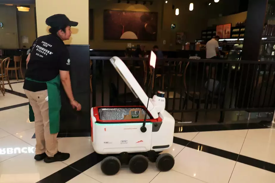 Робот-доставщик забирает заказ от Starbucks в Дубае. Фото: Pawan Singh / The National